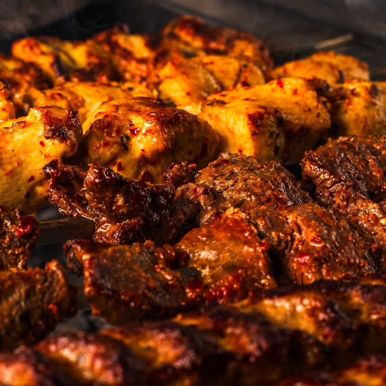 Chicken and lamb shish grilling over charcoal